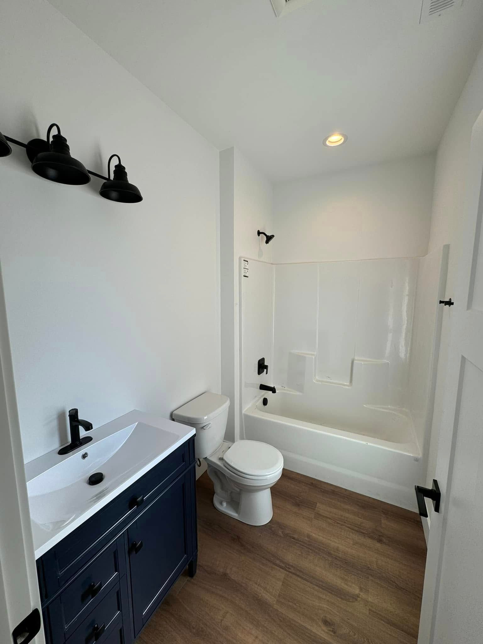 A bathroom with a toilet , sink , bathtub and shower.