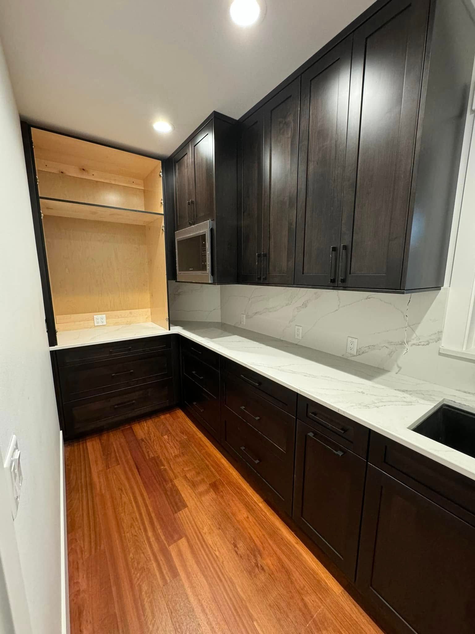 A kitchen with dark wood cabinets and white counter tops