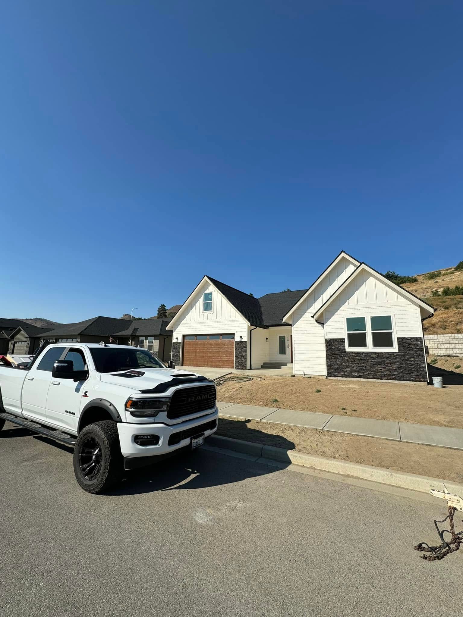A white truck is parked in front of a house.