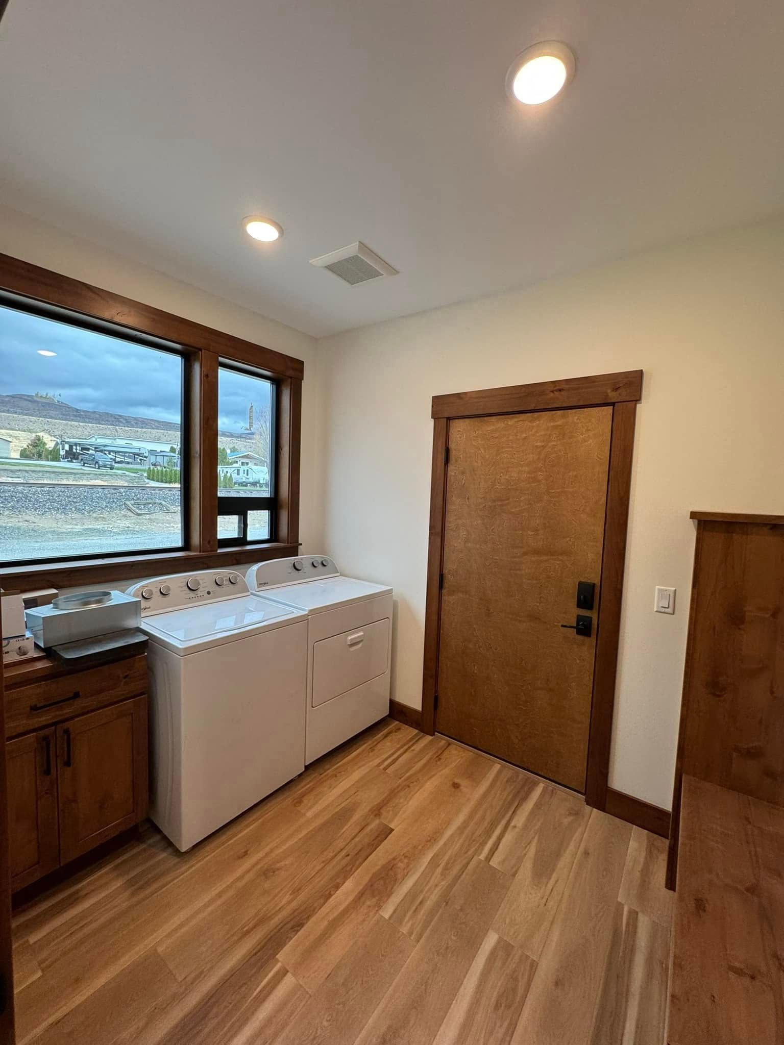 A laundry room with a washer and dryer and a window.