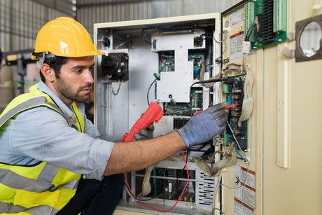 Male electrician worker checking, repair, maintenance operation electric system in factory.