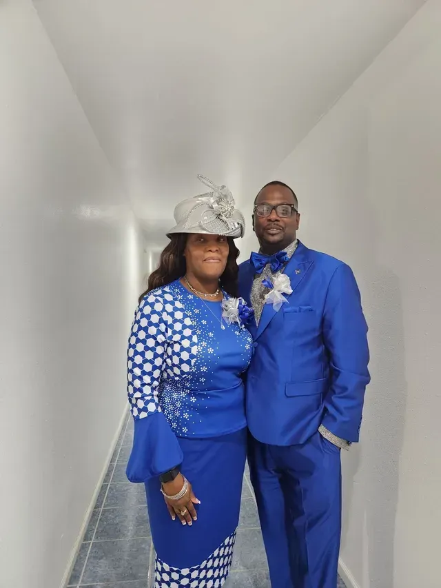 A man and a woman are standing next to each other in a hallway.
