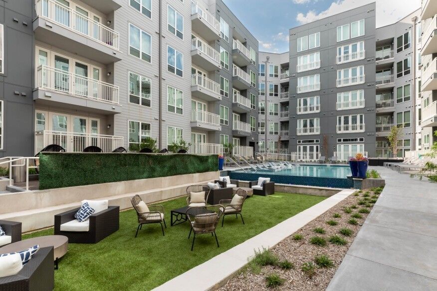 A large apartment building with a swimming pool in the middle of it.