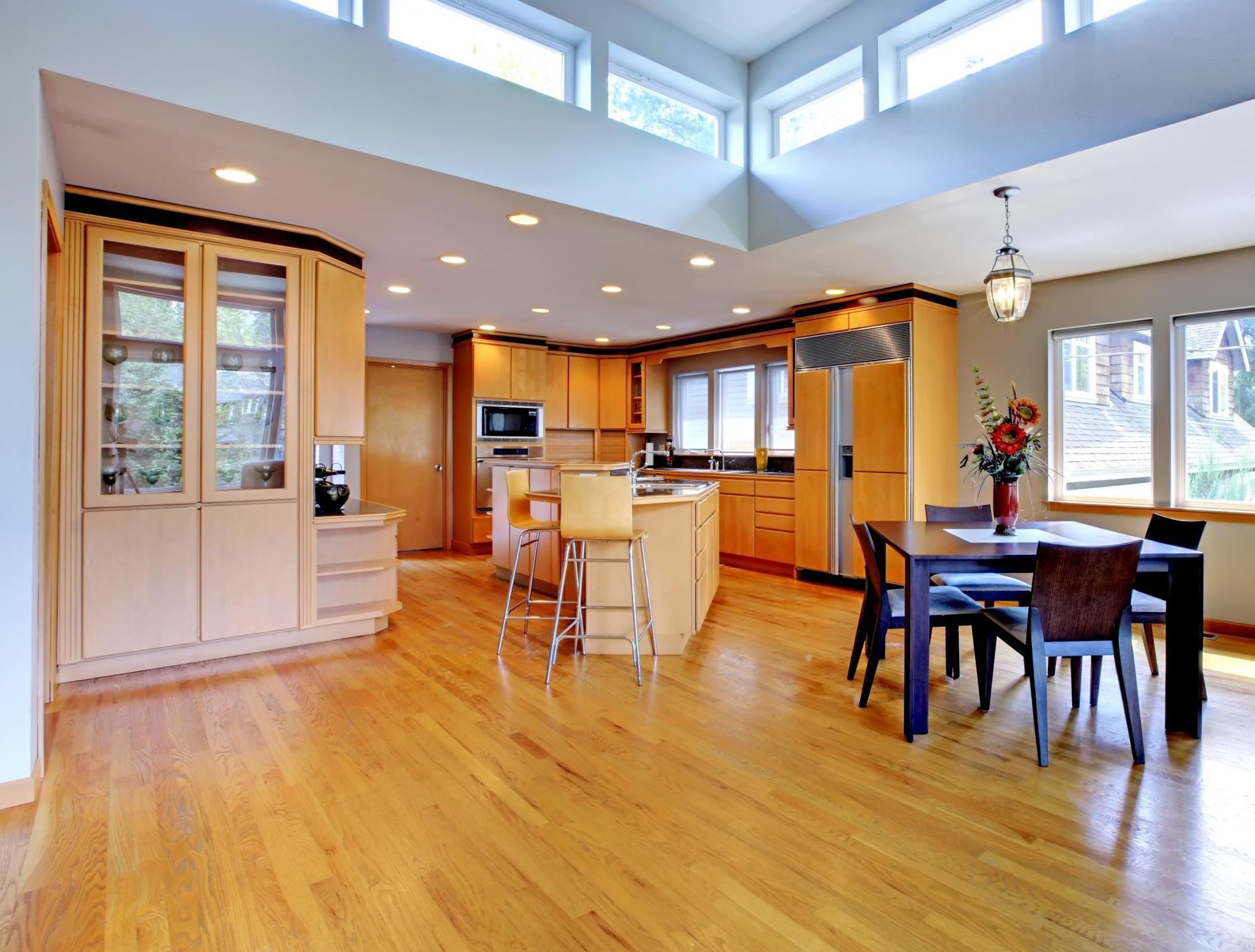 a large open kitchen and dining room with hardwood floors