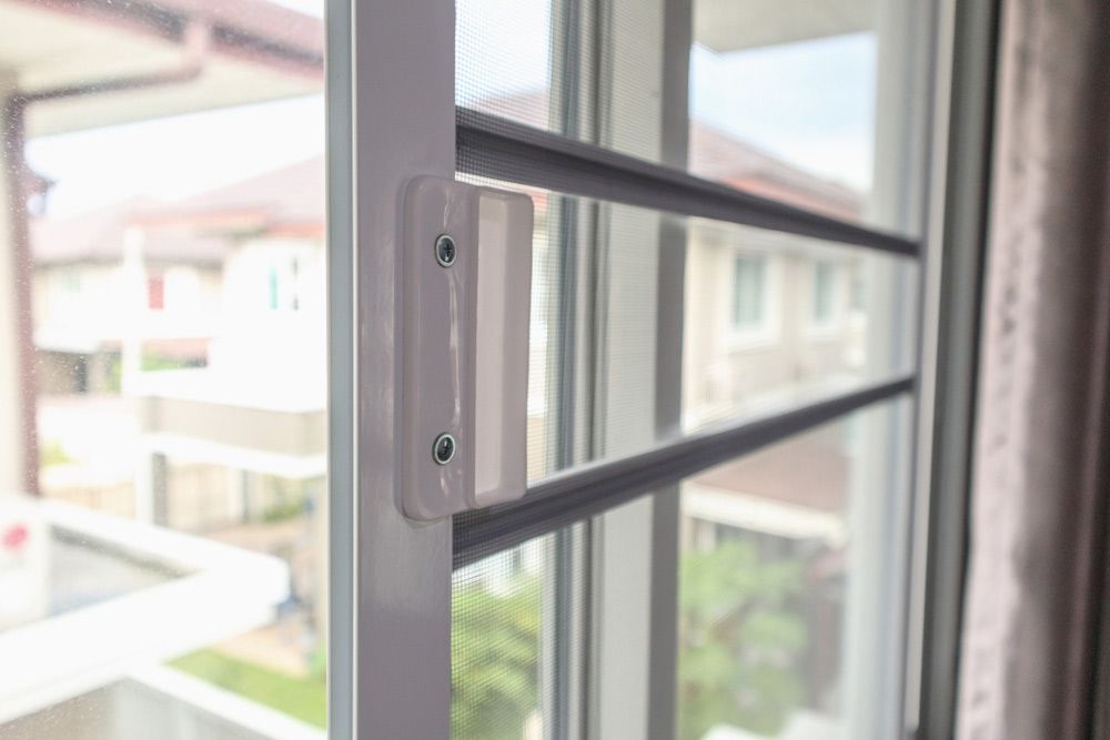 A Close Up of a Sliding Glass Door With a Mosquito Net — Budget Screens & Awnings in Casino, NSW