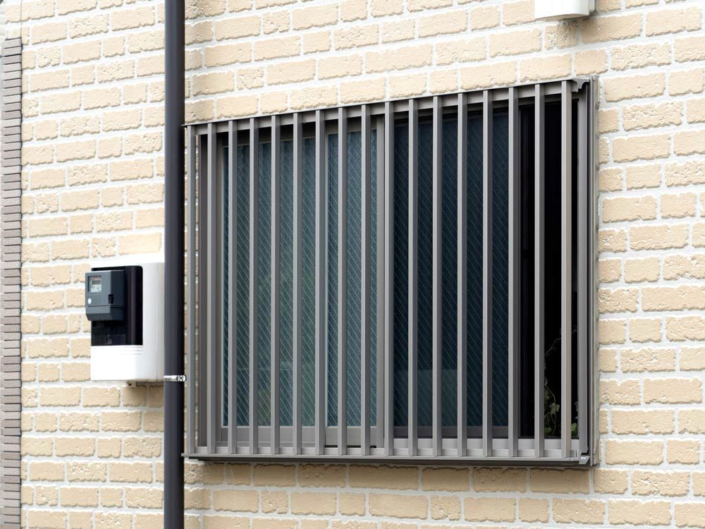 A Brick Wall With a Window With Bars on It — Budget Screens & Awnings in Evans Head, NSW