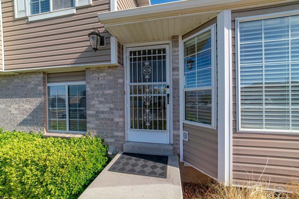 The Front Door of a House With a Metal Gate and a Walkway Leading to It — Budget Screens & Awnings in Ballina, NSW