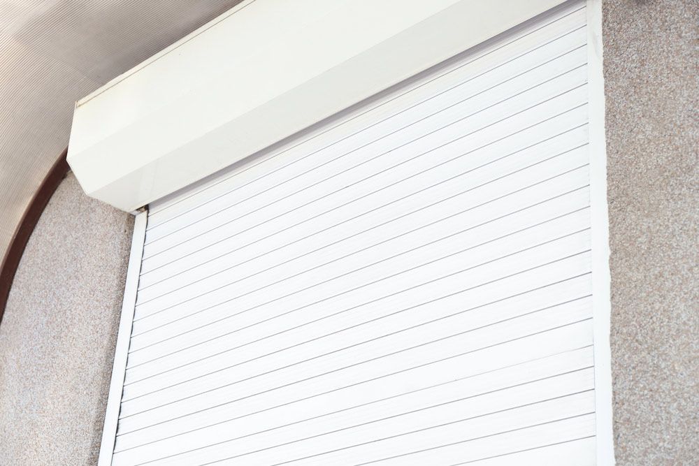 A Close Up of a White Roller Shutter on a Window — Budget Screens & Awnings in South Lismore, NSW