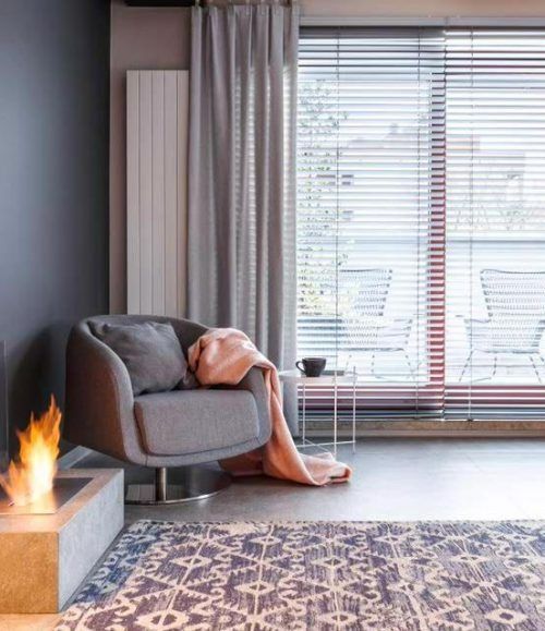 A Living Room With a Chair and a Fireplace — Budget Screens & Awnings in South Lismore, NSW