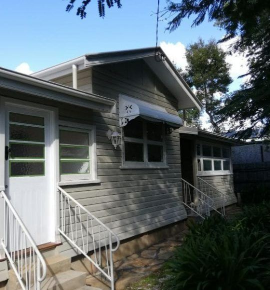 A Small House With a White Awning Over the Front Door — Budget Screens & Awnings in South Lismore, NSW