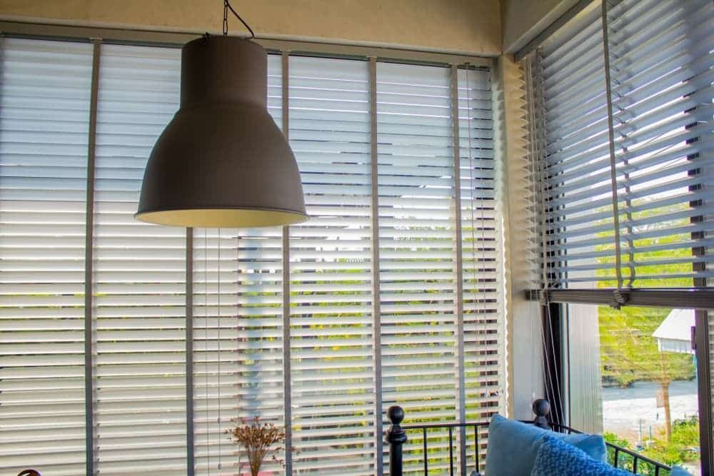 Living Room With Blinds on the Windows and a Lamp Hanging From the Ceiling — Budget Screens & Awnings in South Lismore, NSW