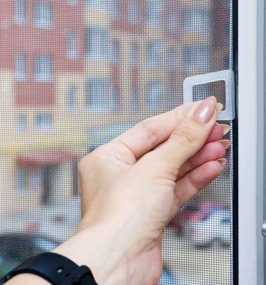 A Close Up of a Person's Hand Holding a Screen Door — Budget Screens & Awnings in South Lismore, NSW