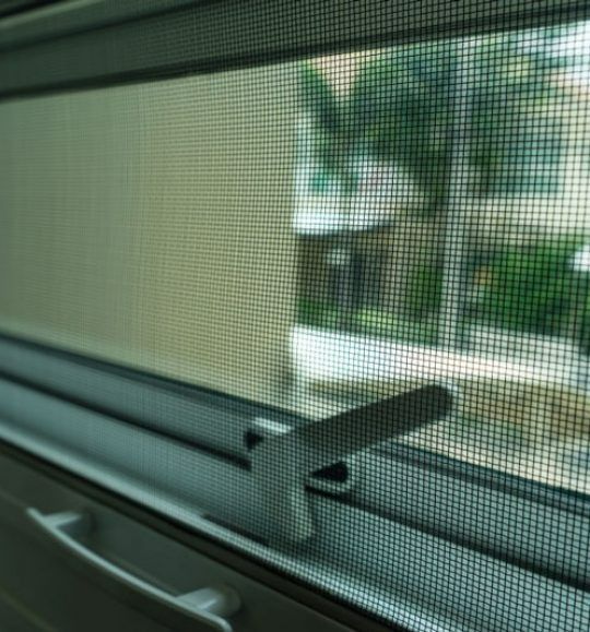 A Close Up of a Screened in Window With a Handle — Budget Screens & Awnings in South Lismore, NSW