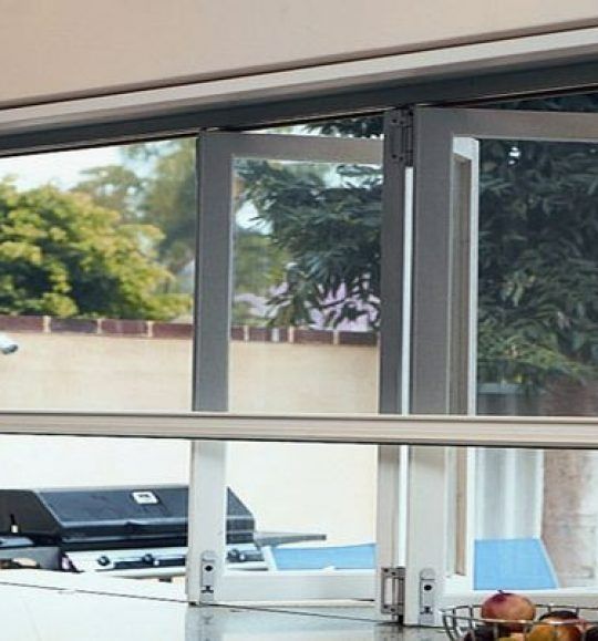 A Kitchen With a Large Window and a Basket of Fruit on the Counter — Budget Screens & Awnings in South Lismore, NSW