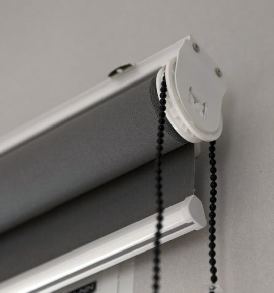 A Close Up of a Roller Blind With Chains Attached to It — Budget Screens & Awnings in South Lismore, NSW