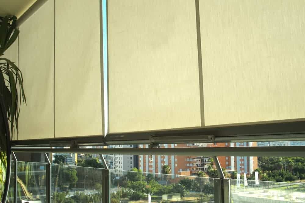 A Balcony With Blinds on the Windows and a View of a City — Budget Screens & Awnings in South Lismore, NSW