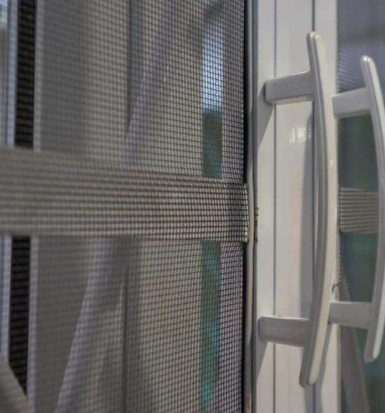A Close Up of a Sliding Screen Door With a Handle — Budget Screens & Awnings in South Lismore, NSW