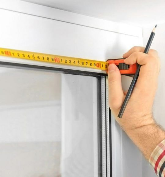 A Person Measuring a Door With a Tape Measure — Budget Screens & Awnings in South Lismore, NSW