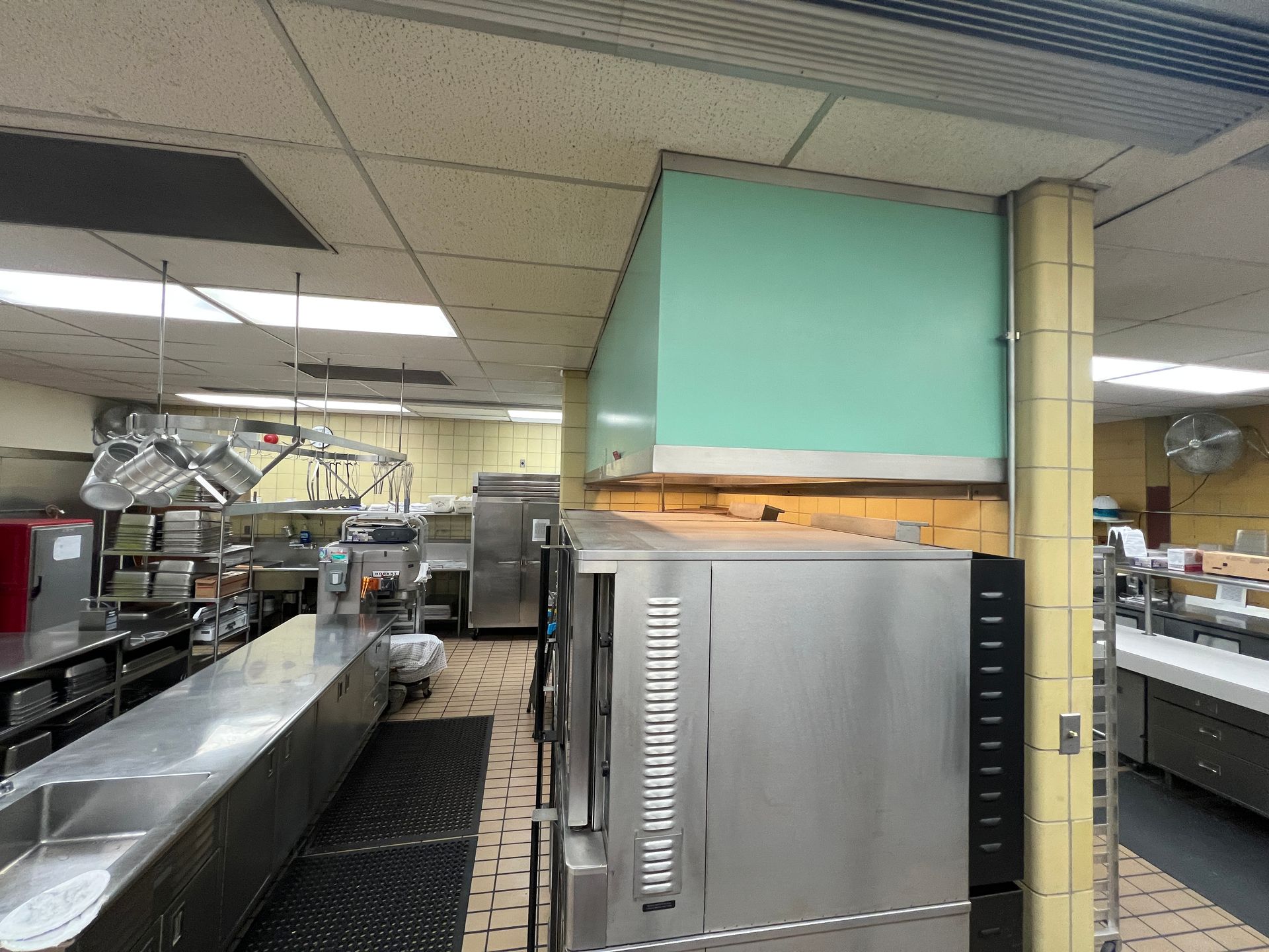 Commercial kitchen, stainless steel ovens, ventilation hood, and prep area.