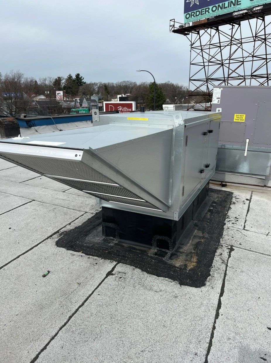 Rooftop air handler unit with a slanted air intake, on a flat roof.