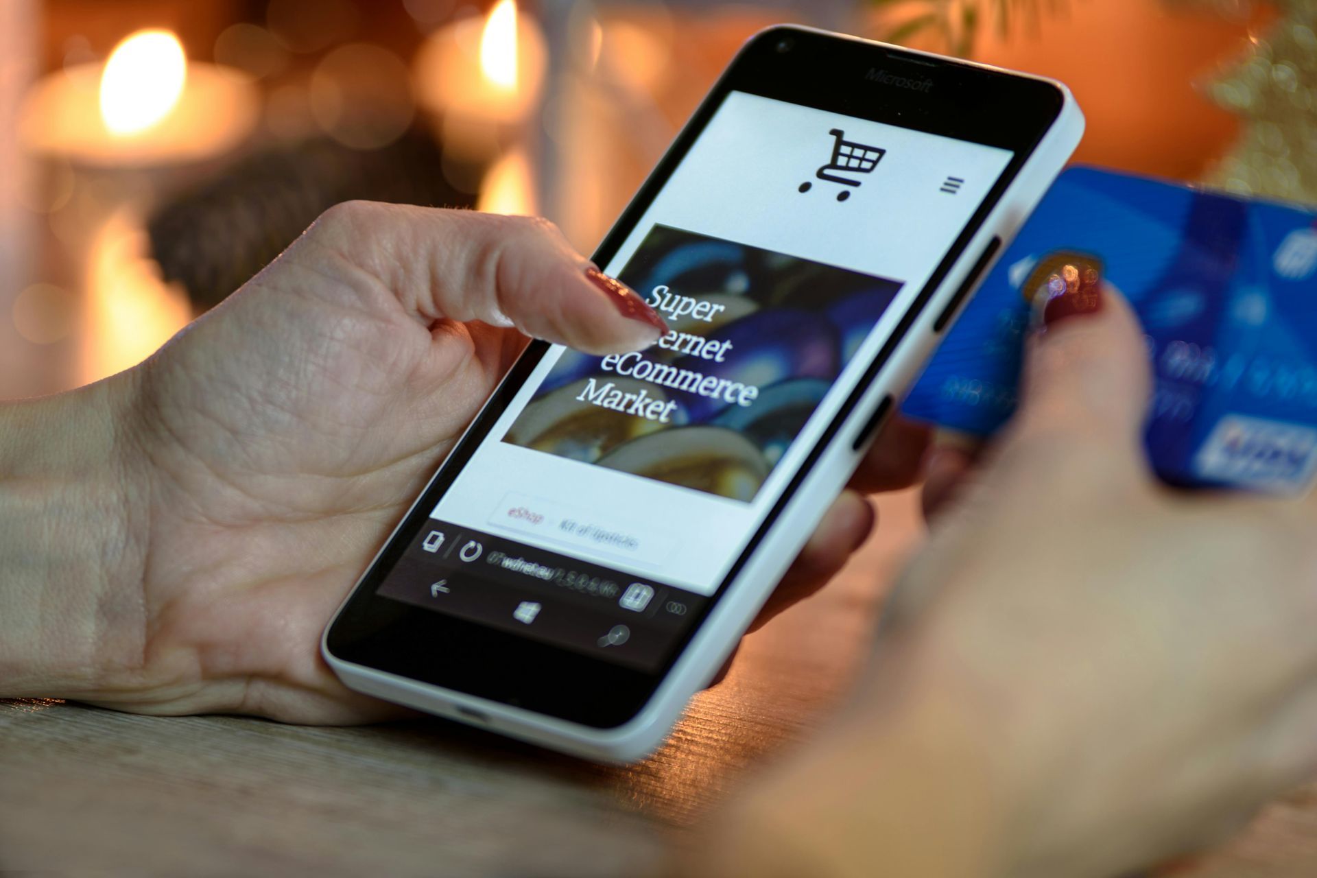 A person holds a smartphone displaying an eCommerce site with a shopping cart icon.