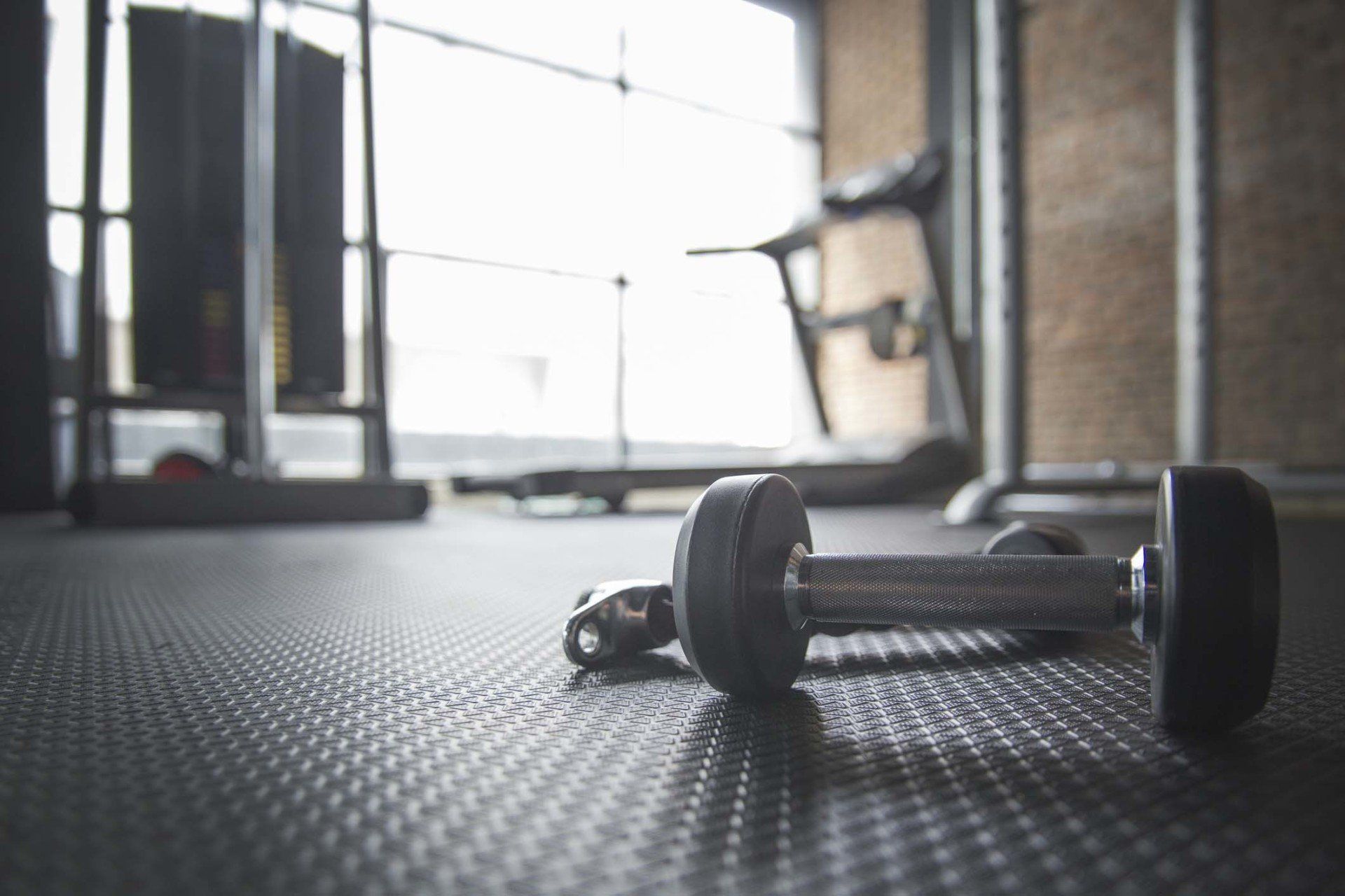 Dumbbell and Rope on the floor in the Gym with treadmill in background