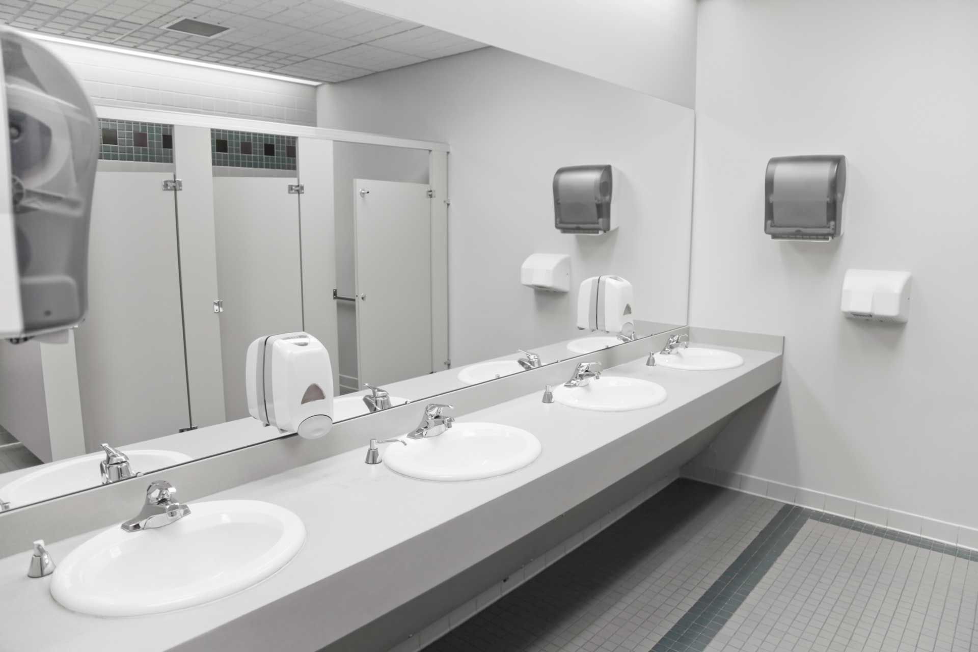 Public restroom with sinks, mirrors, soap, and paper towel dispensers.