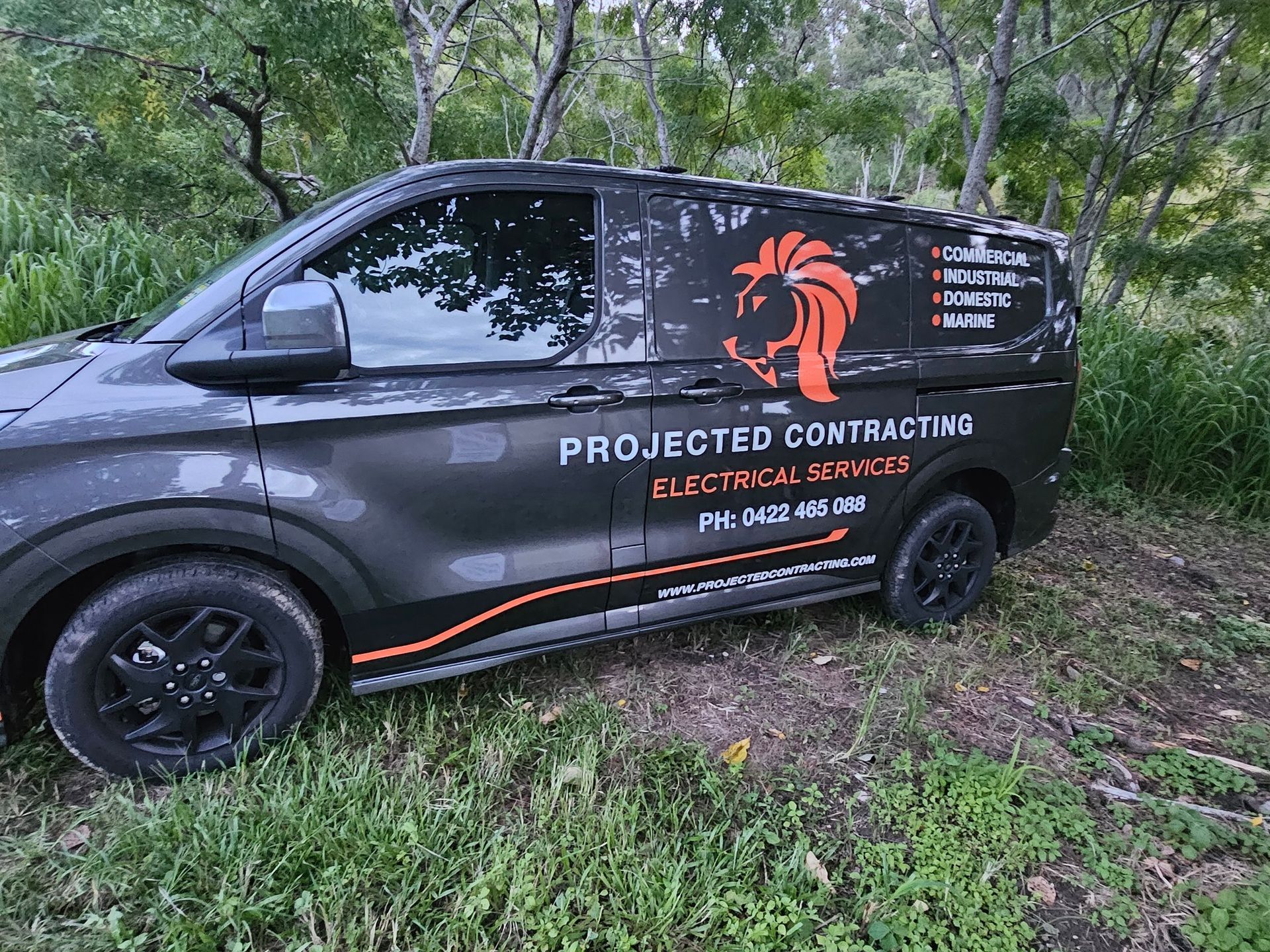 A Technician Using a Screwdriver on An Air Conditioning Unit — Projected Contracting Electrical Services In Portsmith, QLD
