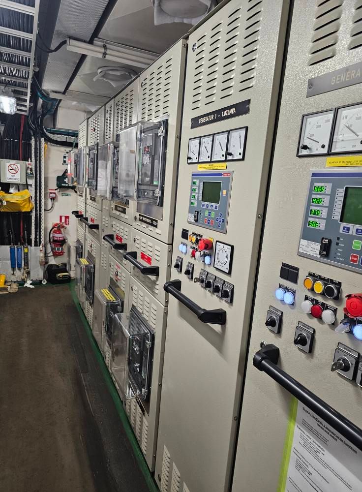 Electrician in Orange Overalls Checking Wires in A Panel — Projected Contracting Electrical Services In Portsmith, QLD