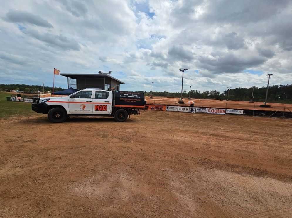 White Utility Truck Parked Near a Dirt Track  — Projected Contracting Electrical Services In Portsmith, QLD