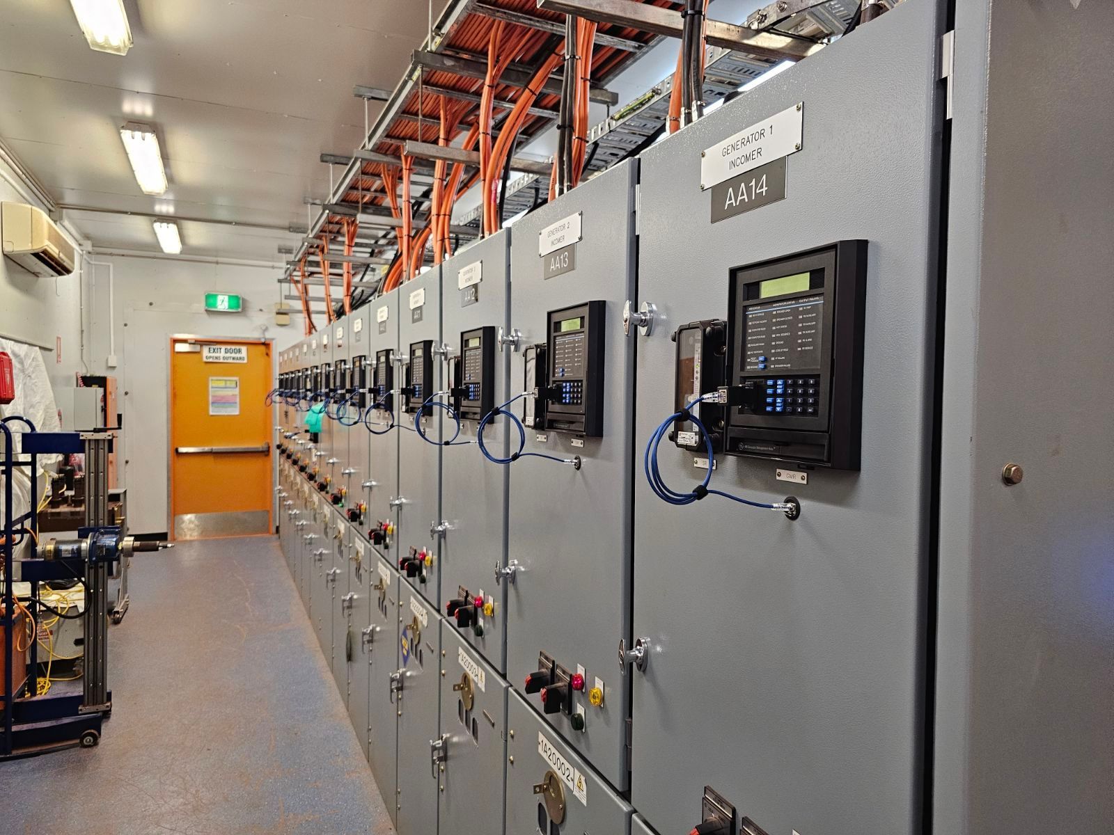 switch room with orange exit door  — Projected Contracting Electrical Services In Portsmith, QLD