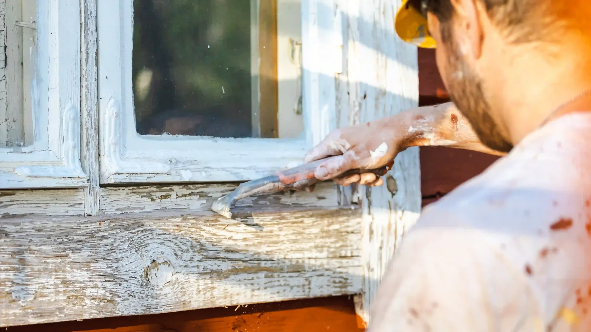 Hilseilevän maalin poisto kaapimella puutalon seinästä