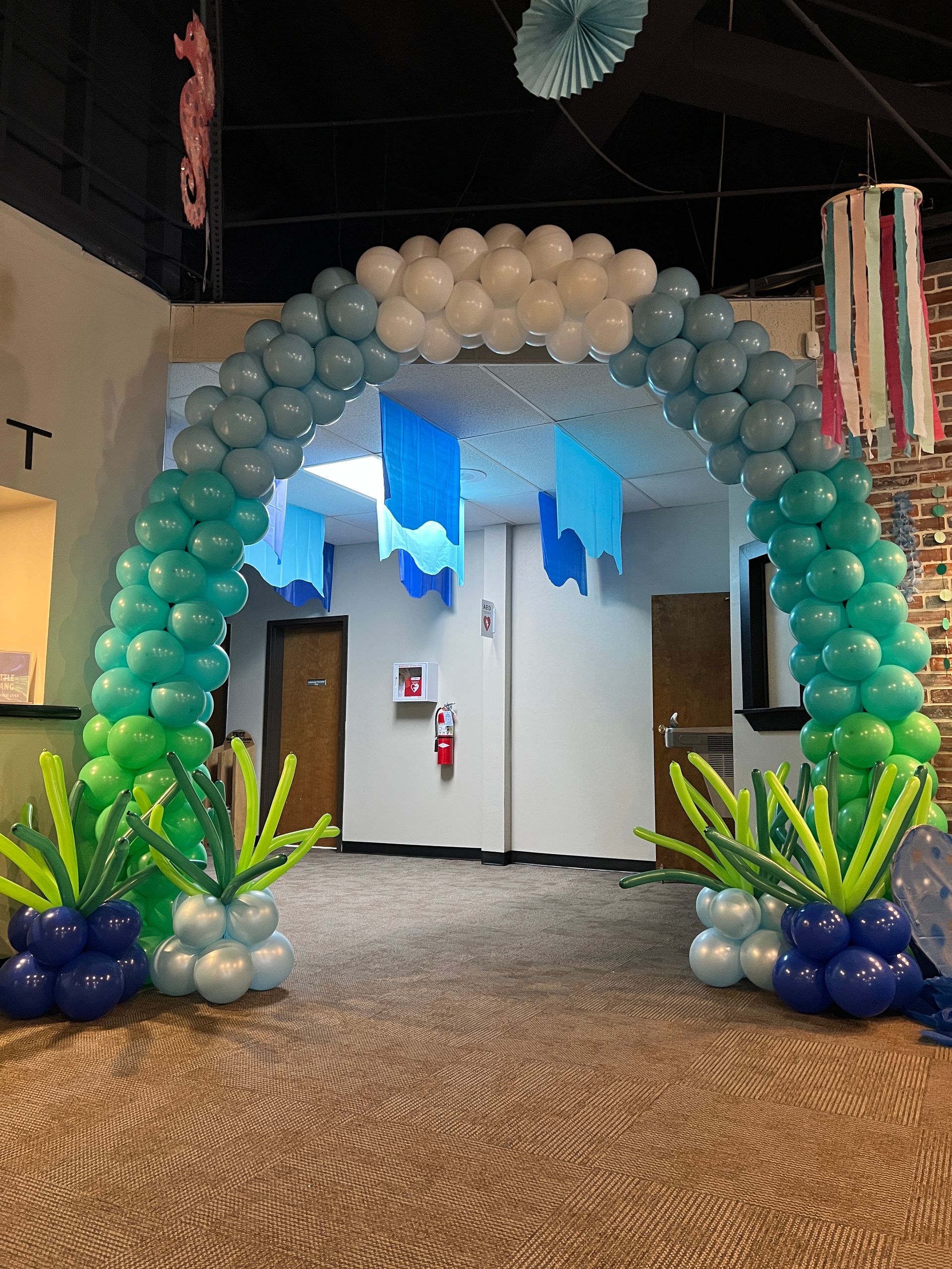 A room decorated with balloons and a balloon arch