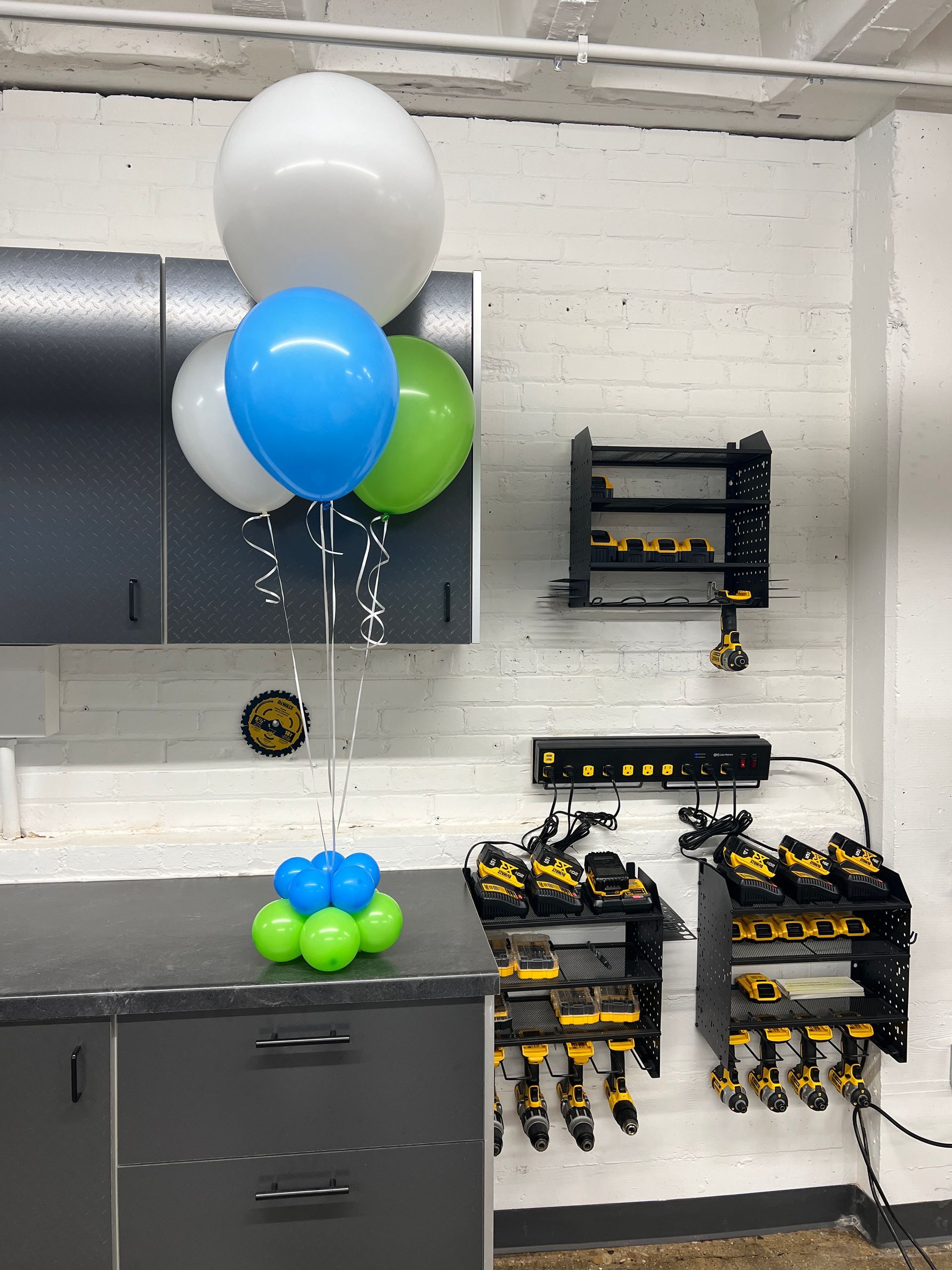 A bunch of balloons are hanging from the ceiling in a garage