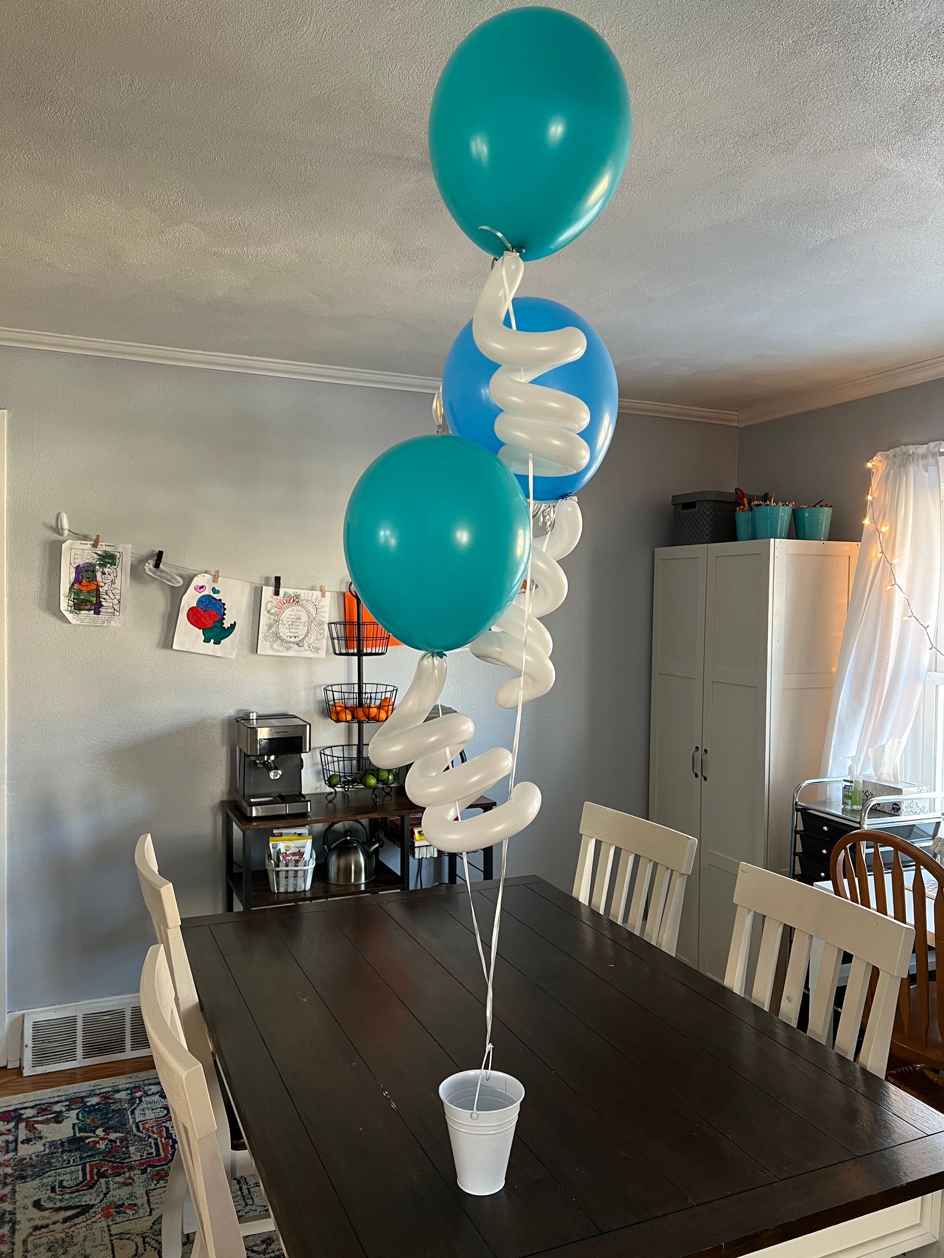 A table with balloons and a cup on it