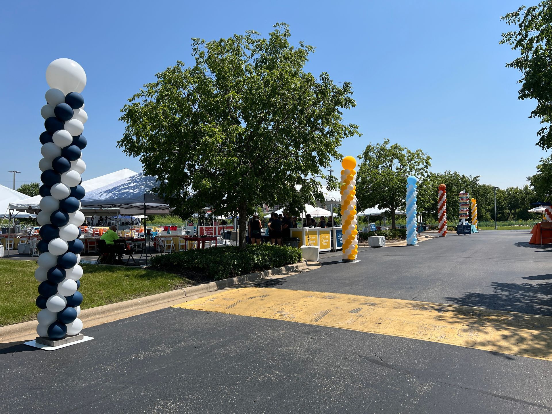 A bunch of balloons are lined up in a parking lot