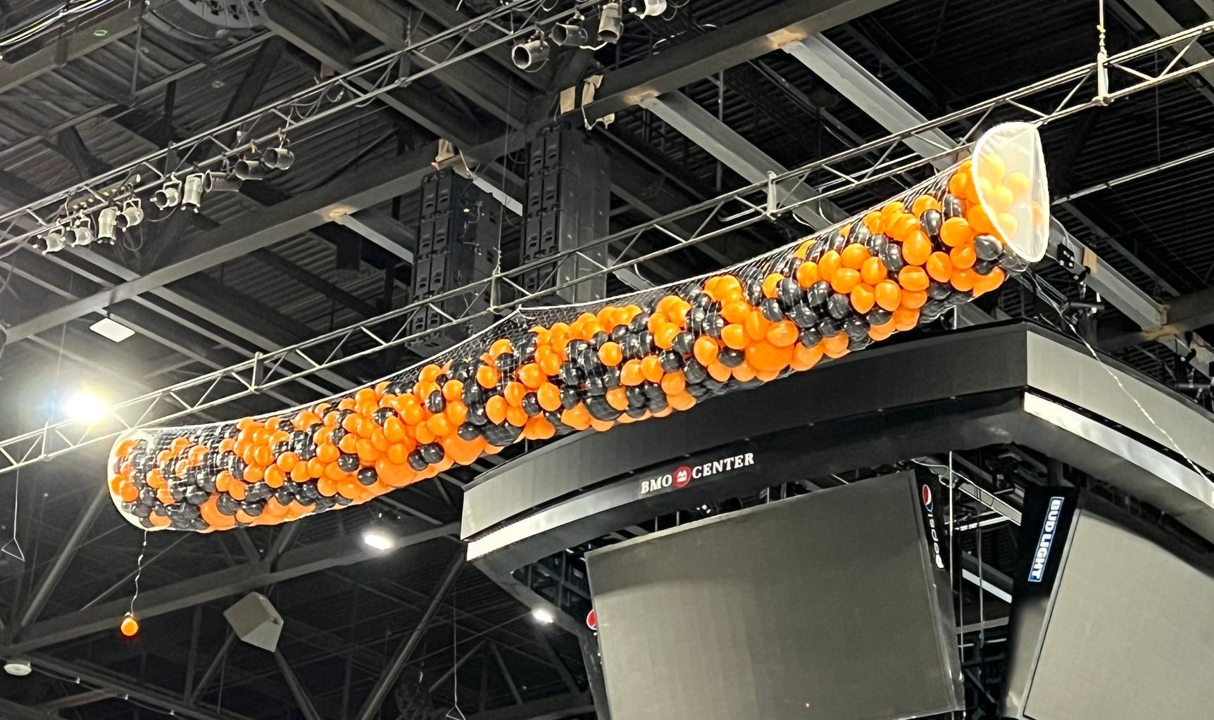 A bunch of balloons are hanging from the ceiling of a building