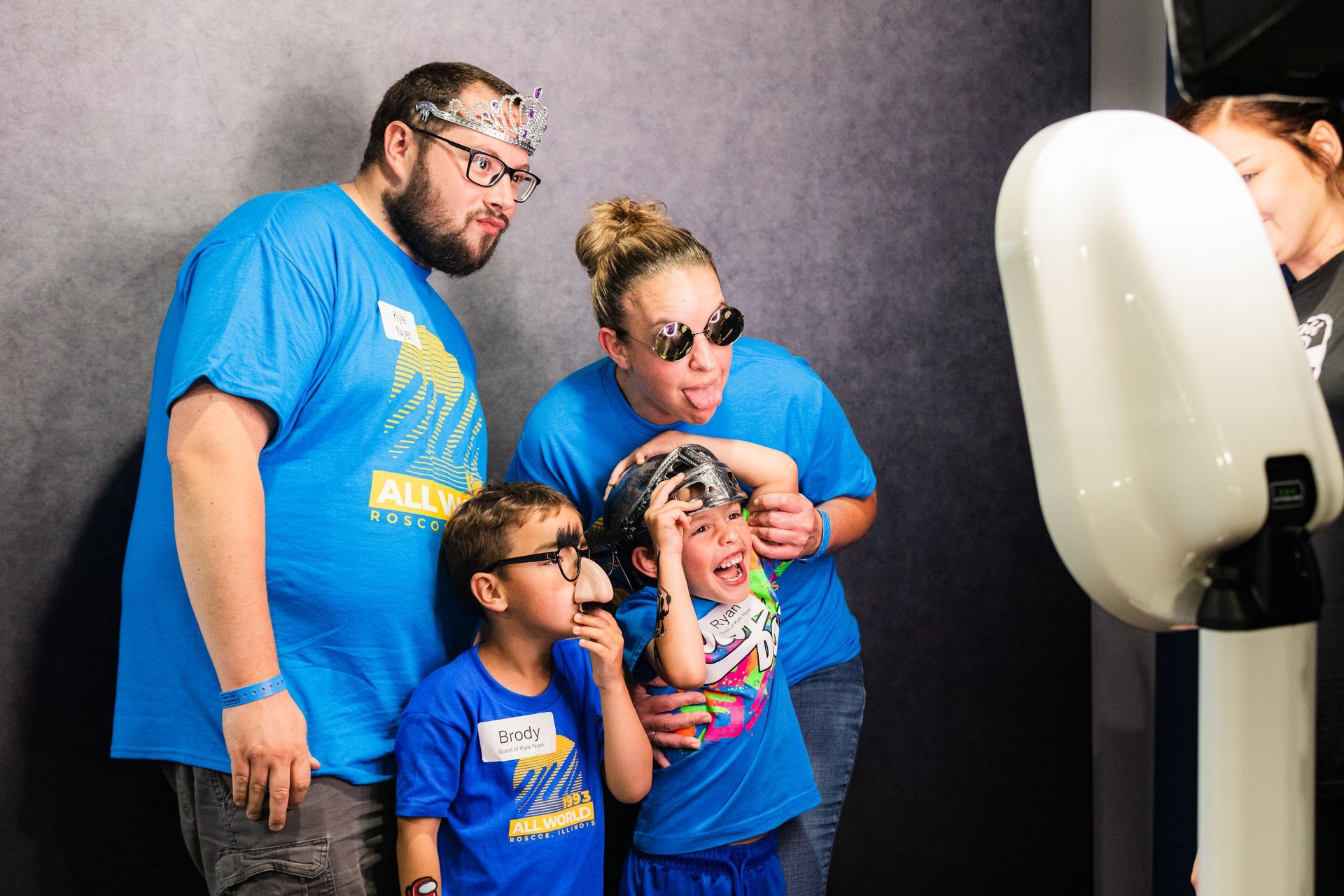 A family is posing for a picture in front of a photo booth.