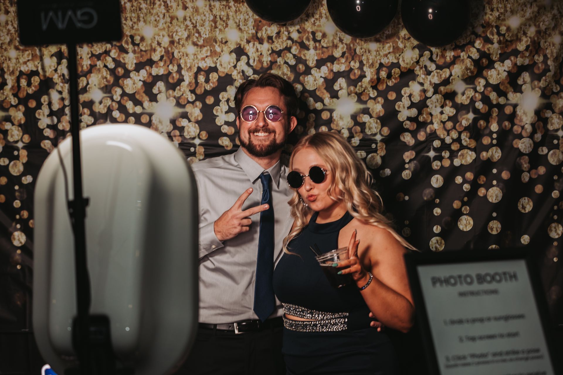 A man and a woman are posing for a picture in a photo booth.