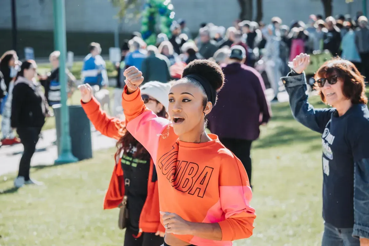 A group of people are dancing in a park.