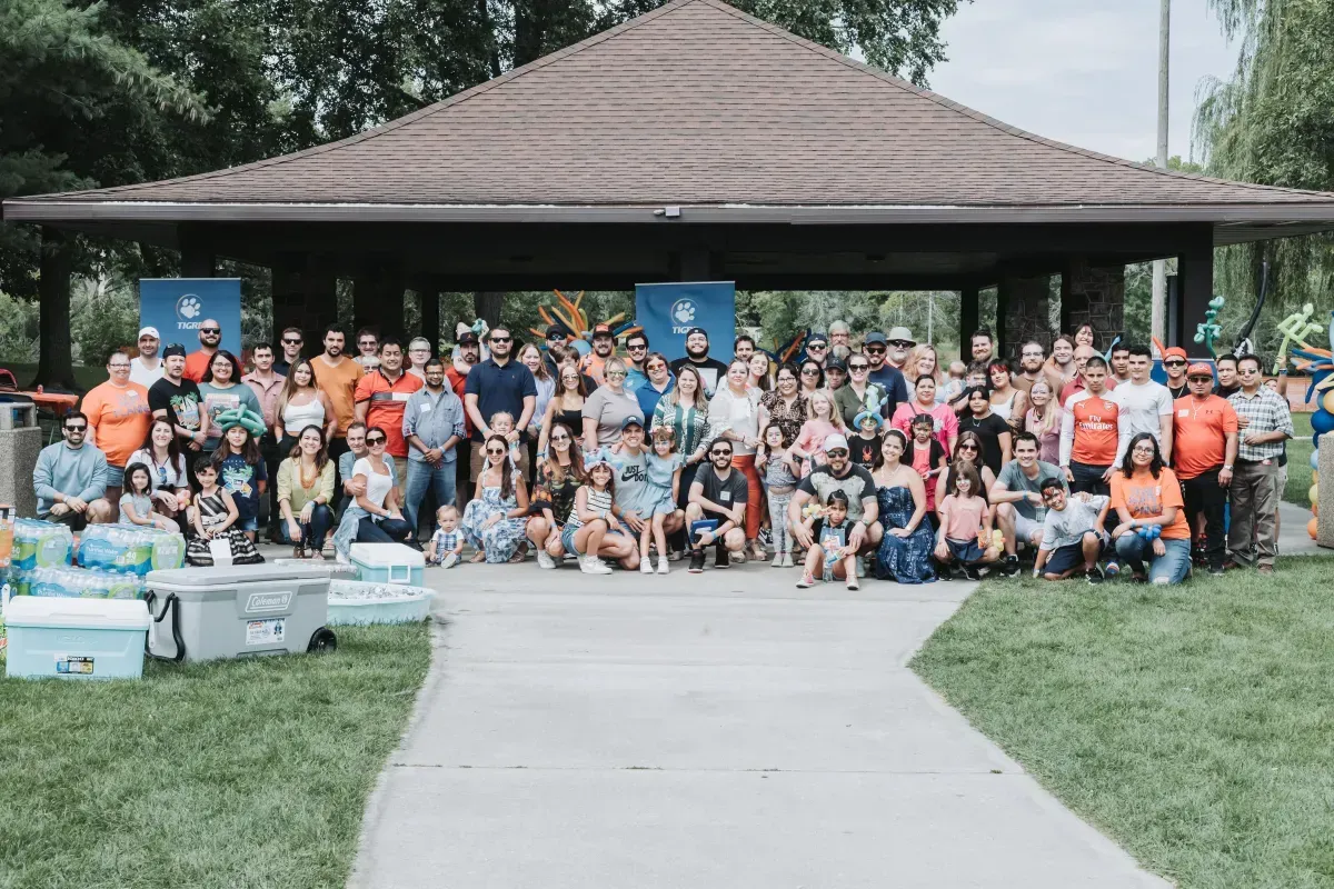 A large group of people are posing for a picture in front of a pavilion.