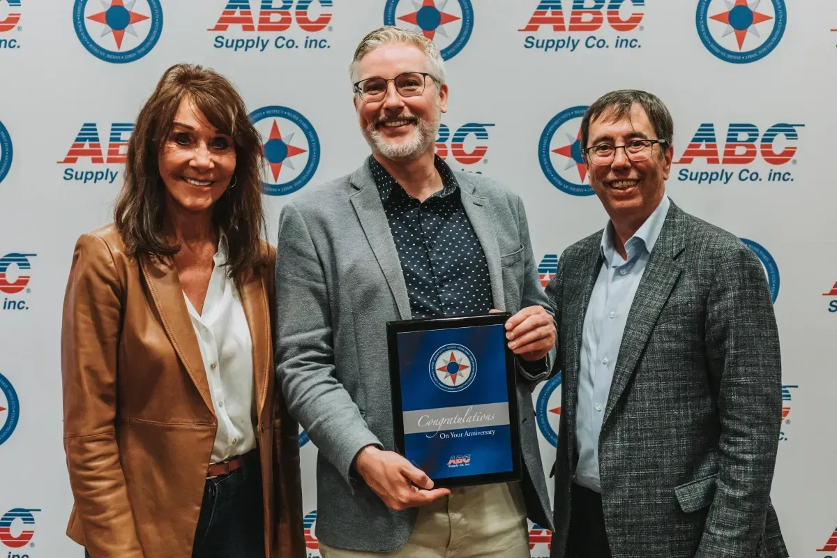 A man and two women are standing next to each other holding a certificate.