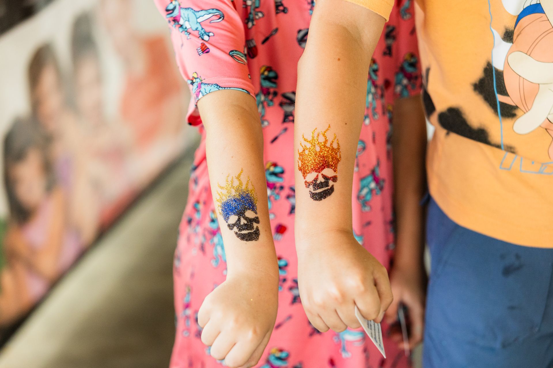 A girl is getting a tattoo on her arm.