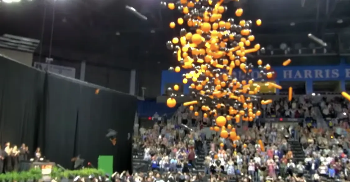Balloons are being thrown in the air at a graduation ceremony