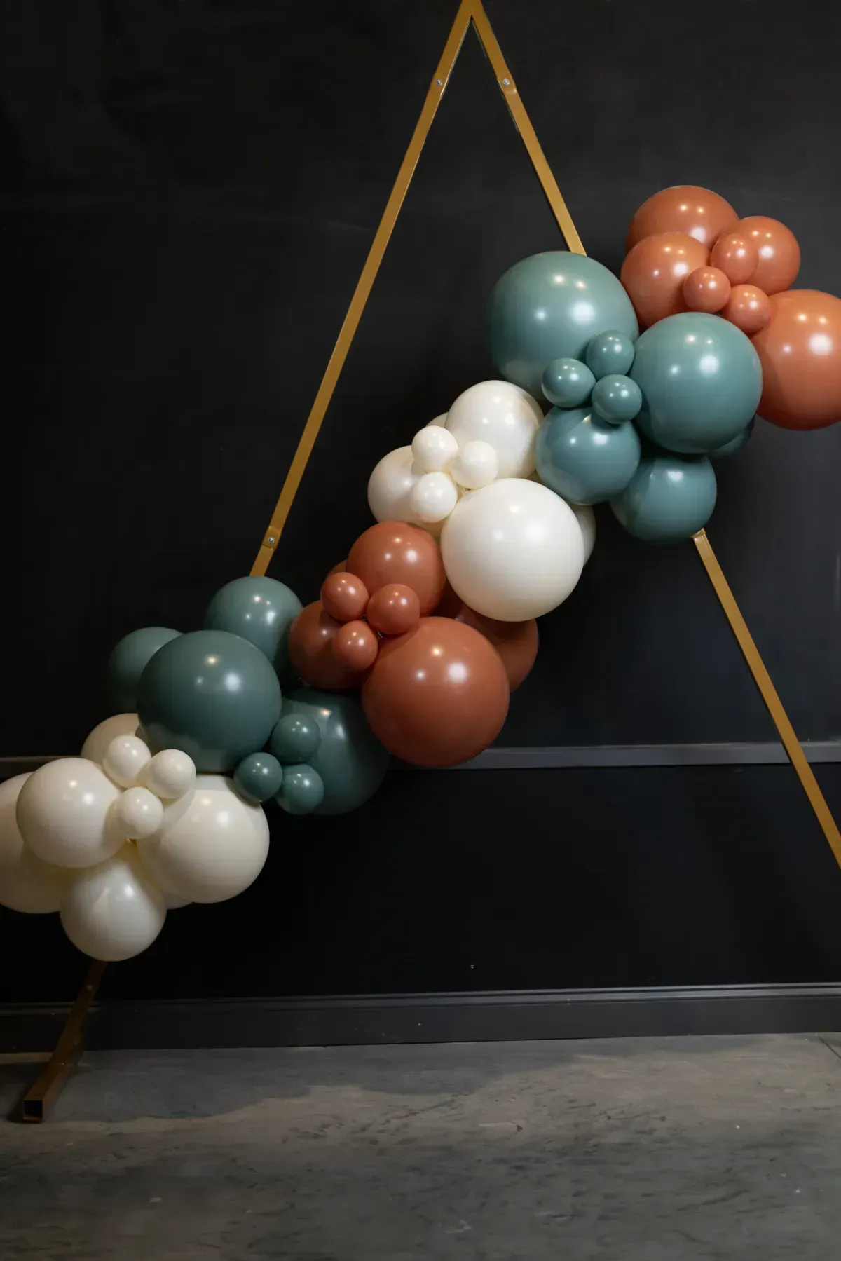 A bunch of balloons are hanging from a string on a wall.