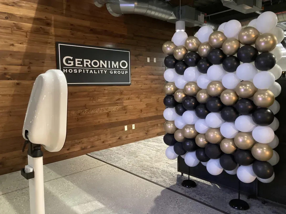 A photo booth is sitting in front of a wall of balloons.