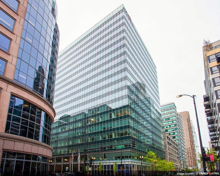 A large building with a lot of windows is in the middle of a city.