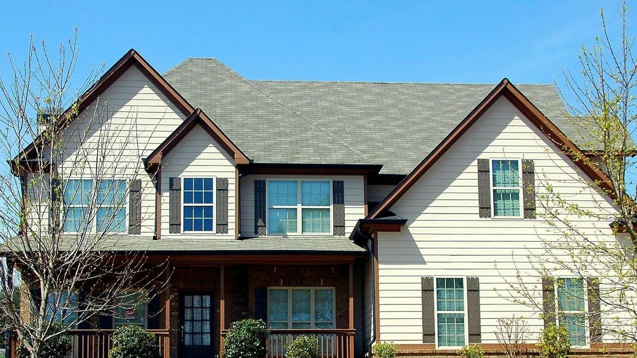 A man is working on the roof of a brick building.