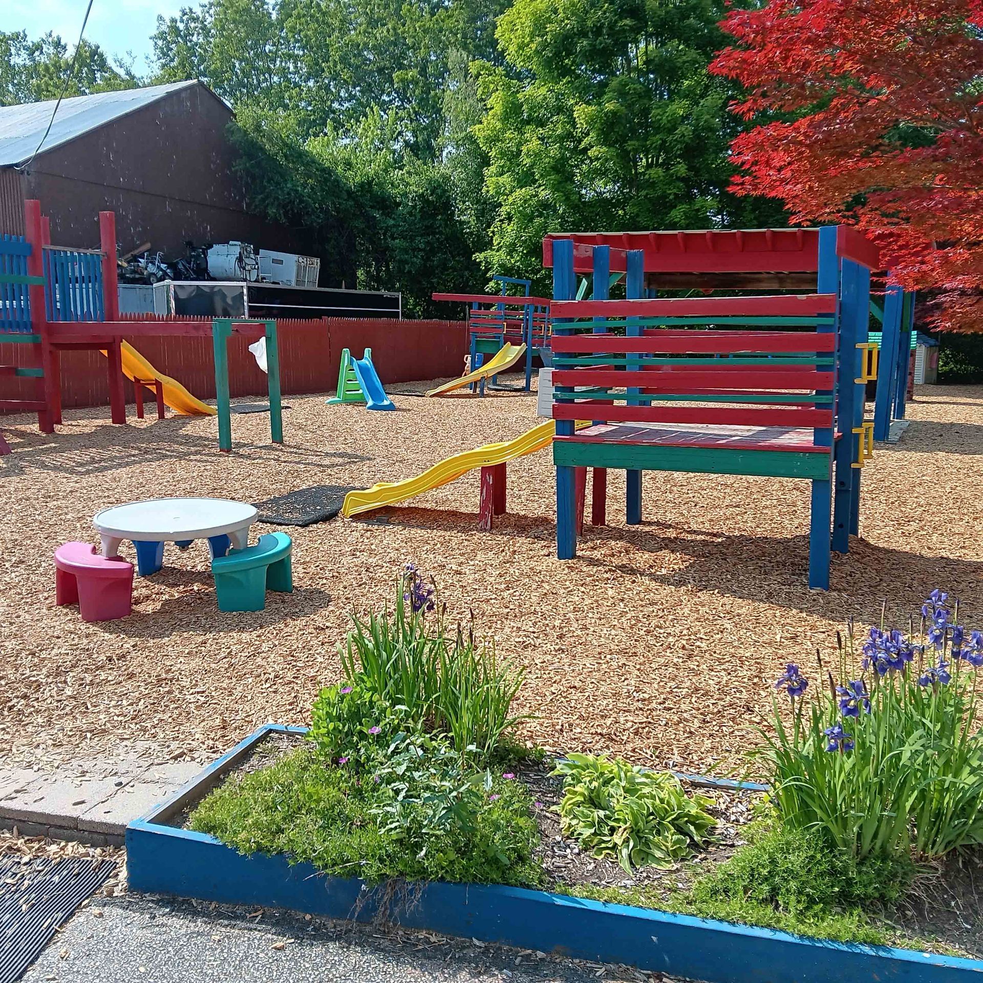 A colorful playground with a slide and a table.