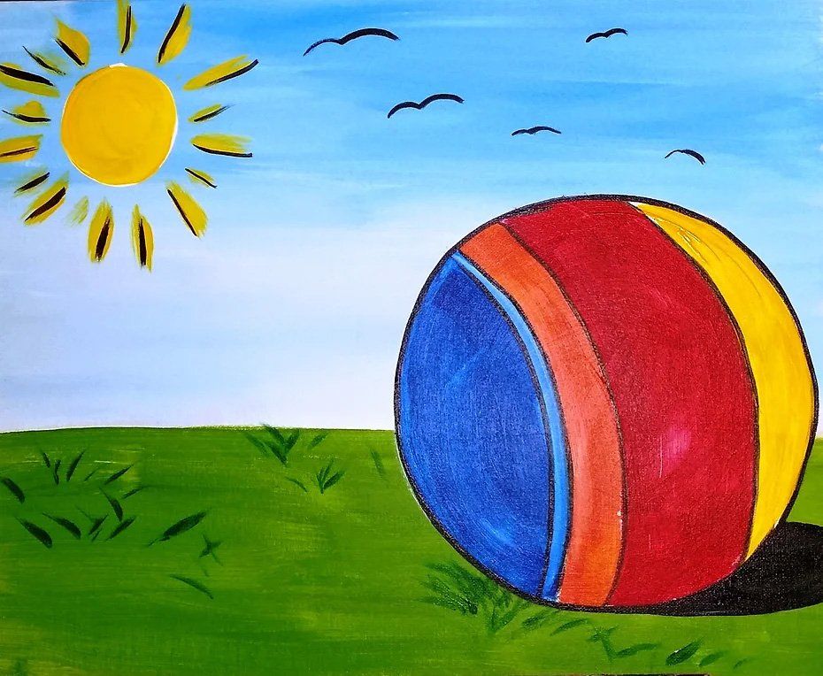 A colorful ball on green grass under a bright sun and blue sky with birds.